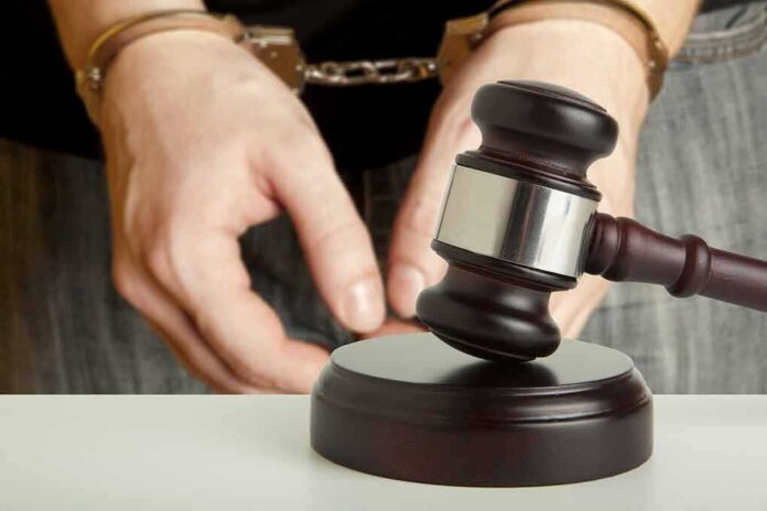 shutterstock_166657139 Handcuffed person behind judge's gavel