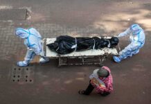 Fentanyl Bombshell Shadows Hayden health workers in PPE move a body on a stretcher