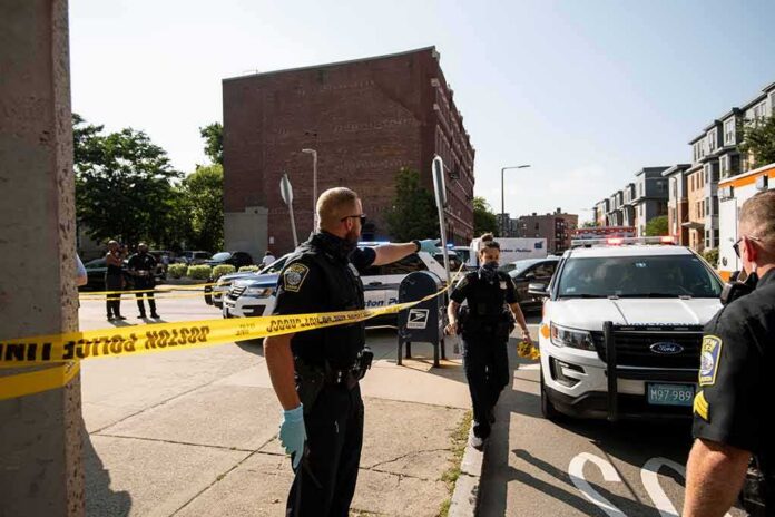shutterstock_1781781026 Police officers secure an urban street with yellow tape near patrol cars