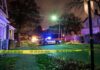 Killer Creeps In – Doctor Slain In Bed Police car blocks residential street at night behind caution tape