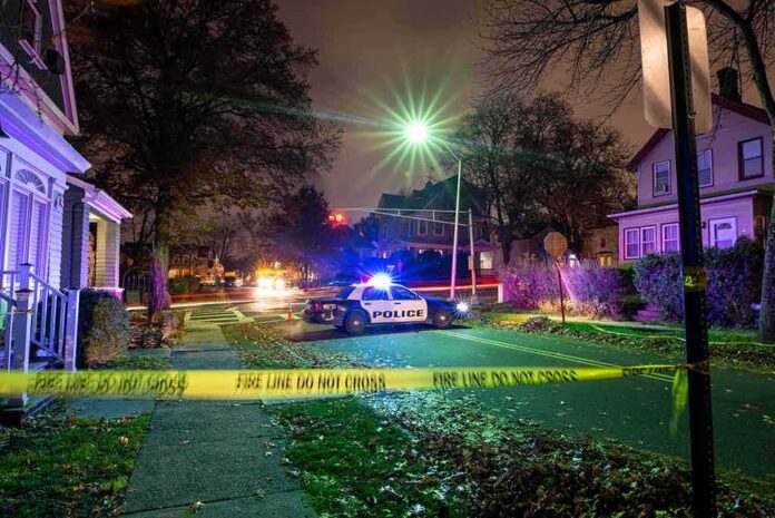 shutterstock_1793905801-1 Police car blocks residential street at night behind caution tape
