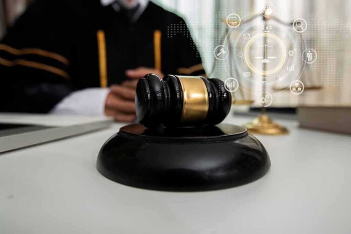 shutterstock_1903169269 Judge's gavel on a desk with scales of justice in background