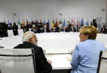 Stunned UN As US Walks Out Angela Merkel and Narendra Modi seated at a large round table during an international summit