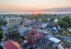 Small town at sunrise with historic buildings and tree-lined streets