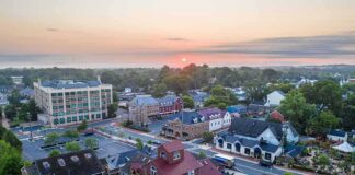 Small town at sunrise with historic buildings and tree-lined streets