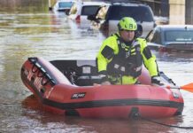 Coastal Floods Loom – Hochul Sounds Alarm Rescue worker in an inflatable boat during urban flooding