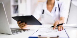 Healthcare worker using tablet and filling out form