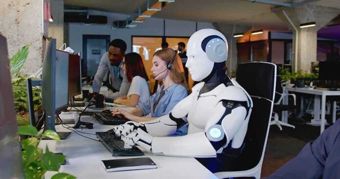 shutterstock_2229125163-1 Robot and office workers at computers in a modern workspace