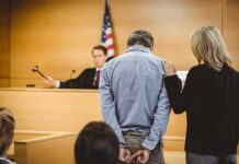 Trump Torpedoes Contested Gun Conviction Defendant in handcuffs stands before a judge in a courtroom