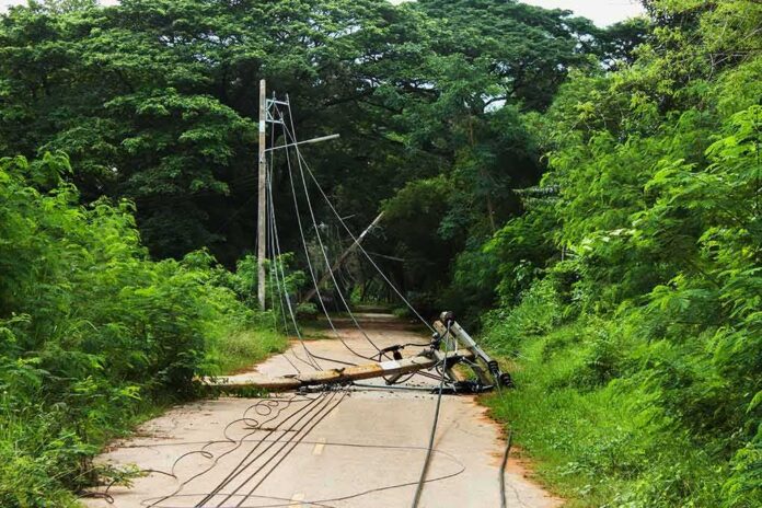 shutterstock_314157362 Fallen utility pole blocking a rural road