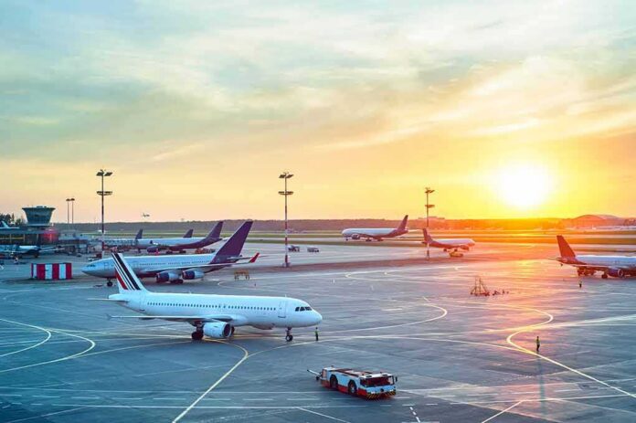 Airplanes on airport tarmac at sunset