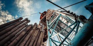 Oil drilling rig structure with stacked pipes viewed from below