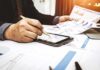 Caregiver Payroll Scam? Feds Move In Businessperson analyzing charts with tablet and papers