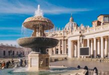 Stone fountain in front of a grand basilica with dome and colonnade