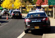 Midnight Gunfire Shatters Vienna Homecoming Police cars with flashing lights near school buses on a city street