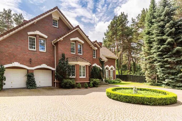 shutterstock_1205882497 Red brick house with circular driveway and fountain