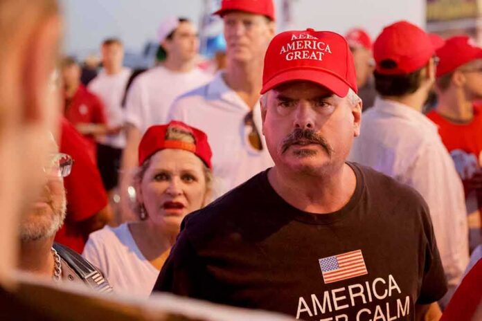 shutterstock_1207940563 Darren Balsley in a red cap at a crowded outdoor event