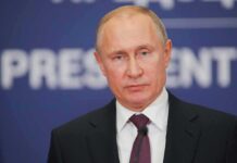 Vladimir Putin at a podium with microphone
