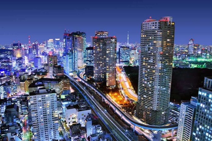 shutterstock_132066608 City skyline at night with illuminated skyscrapers and highways