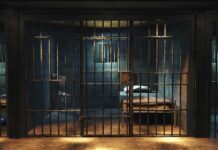 Public Execution Broadcast – Rules Thrown Out Prison cell with metal bars and a single bed