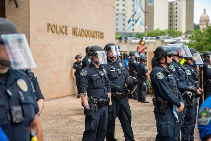 shutterstock_1747618742 Teddy Williams and Carlos Hyde among police officers in riot gear outside police headquarters