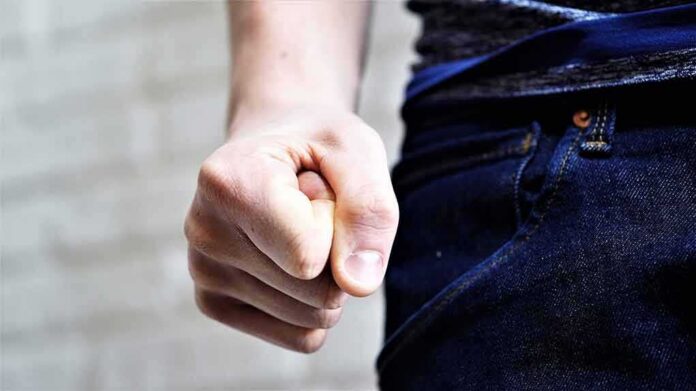 shutterstock_1923214790 Clenched fist by a person wearing jeans
