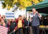 Man with megaphone addressing crowd at outdoor rally