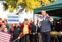 Man with megaphone addressing crowd at outdoor rally