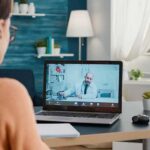 Woman on laptop having video call with doctor in home office