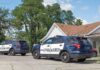 Two police SUVs parked near a suburban house