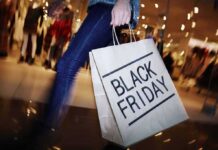shopper holding a large paper bag in a mall
