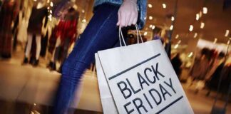shopper holding a large paper bag in a mall