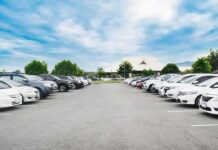 Campaign Fight Escalates – Felony Charge Filed Parking lot lined with cars under a blue sky